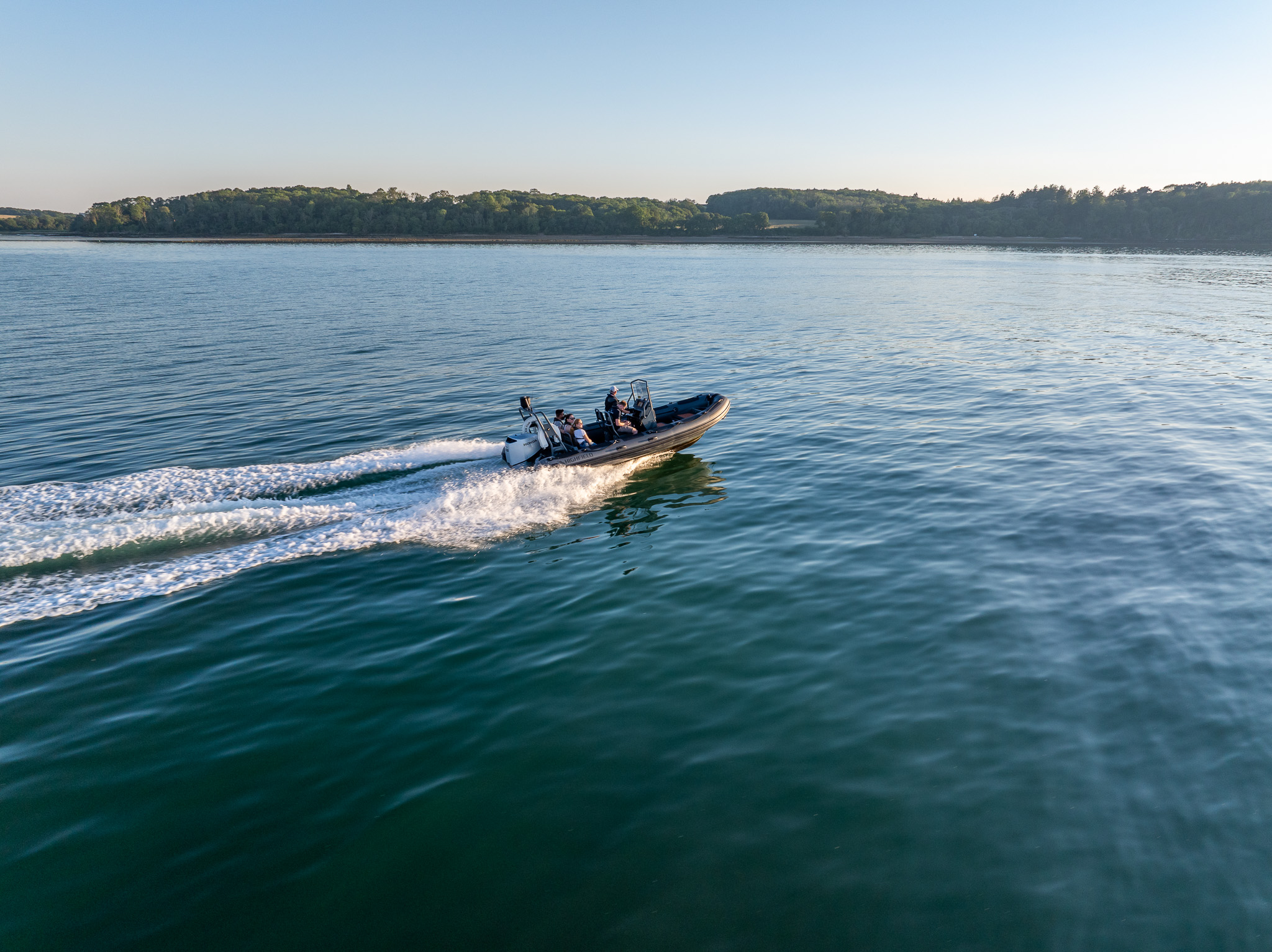 Aerial view of a RIB boat passing the Hampshire shoreline