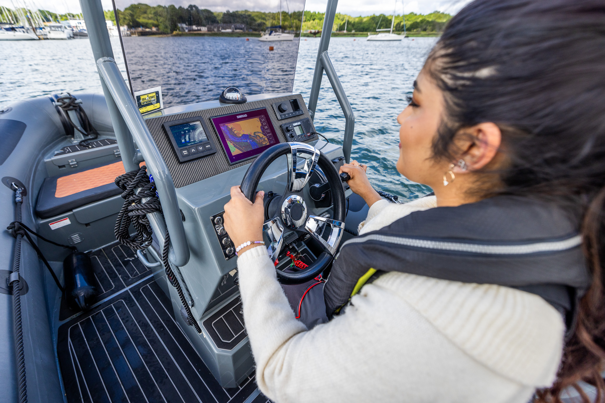 Skipper at the helm, instruments visible over shoulder