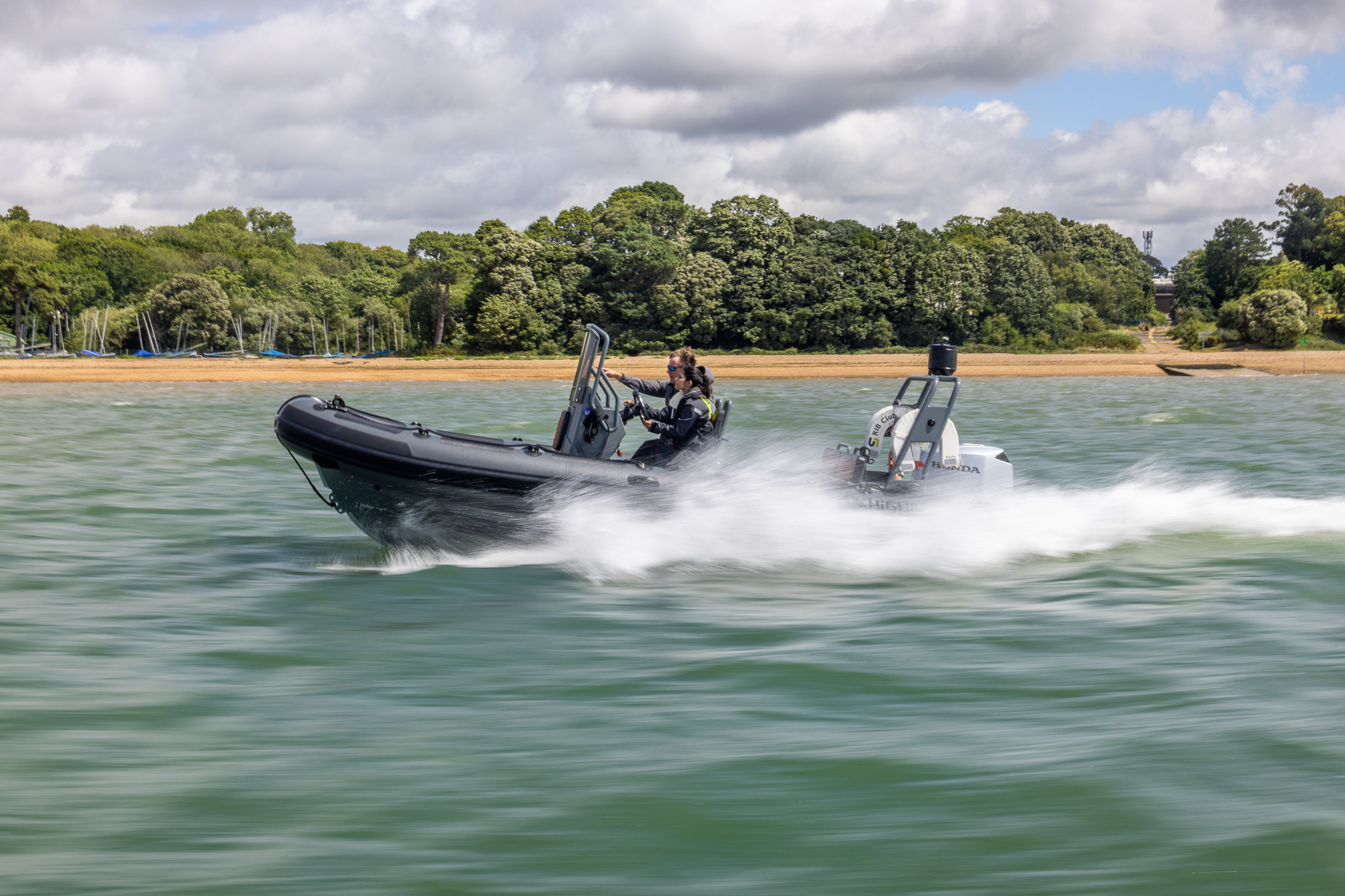 Highfield 600 RIB at speed with beach backdrop